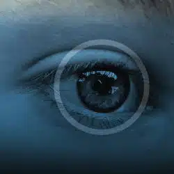 Close-up of a blue-tinted eye with concentric rings around the pupil.