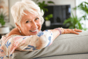Smiling senior woman relaxing at home for the Barnet Dulaney Perkins Eye Center what are cataracts blog