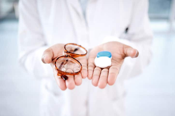 Eye care, choice with glasses or contact lens in hands, closeup and vision with healthcare for eyes.