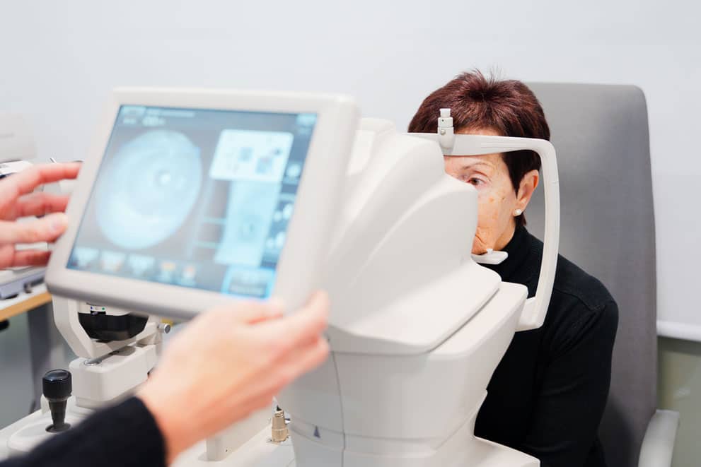 Patient undergoing an eye exam with advanced diagnostic imaging equipment at an ophthalmology clinic.