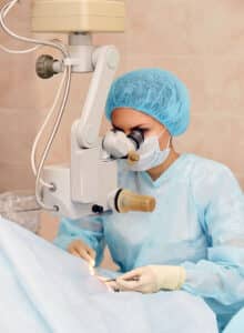 Surgeon performing corneal transplants under a surgical microscope
