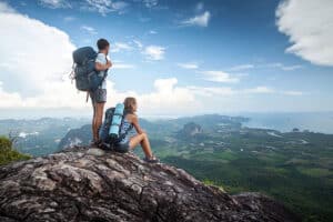 Elevation and retina surgery: two hikers overlooking a mountain valley, illustrating the impact of altitude changes on postoperative eye recovery