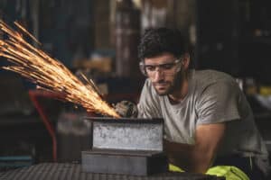 cornea conditions - Metalworker wearing safety goggles to prevent cornea conditions from sparks and debris.