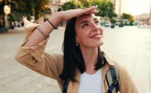LASIK in Phoenix — smiling woman outdoors shielding her eyes from the sun