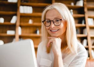 Smiling patient using laptop with clear vision after LASIK surgeon in Scottsdale