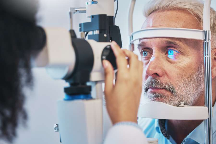 Ophthalmology, medical and eye exam with old man and consulting for vision, healthcare and glaucoma check. Laser, light and innovation with face of patient and machine for scanning and optometry stock photo