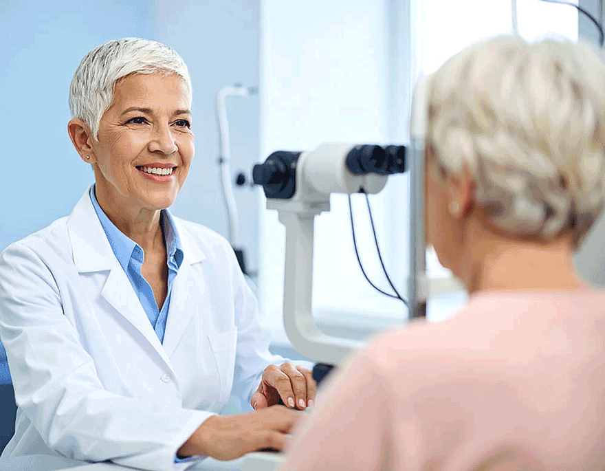 A close-up photo of an ophthalmologist in a white coat speaking with an older patient in a well-lit clinic about glaucoma causes and types. Expert glaucoma treatment in Arizona starts with early diagnosis and personalized care from trusted eye specialists.