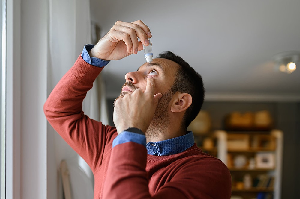 Man applying lubricating eye drops for dry eye symptoms