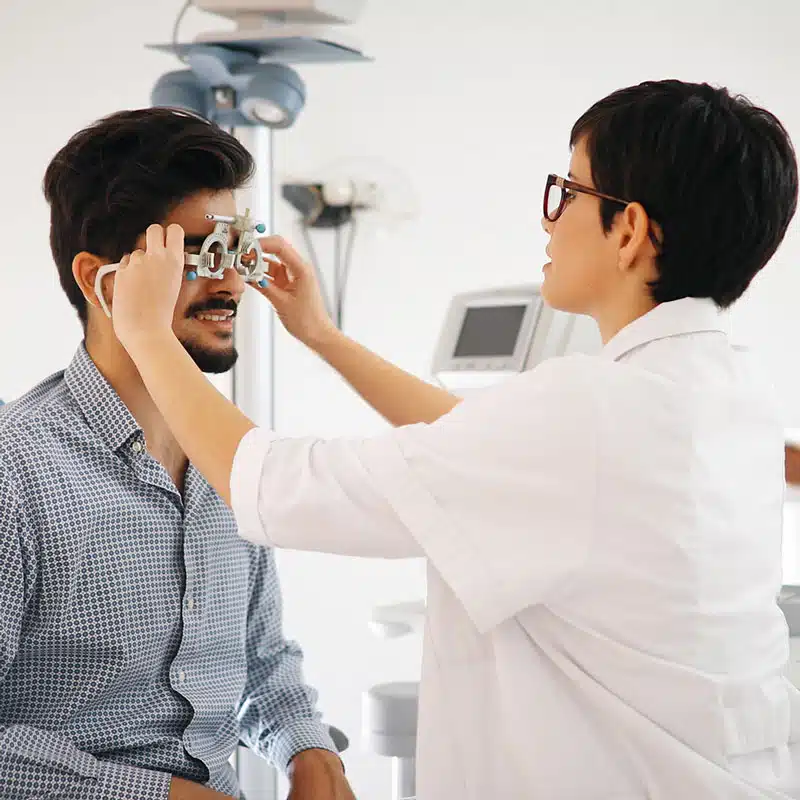 Eye doctor fitting a trial frame during a patient’s comprehensive eye exam.
