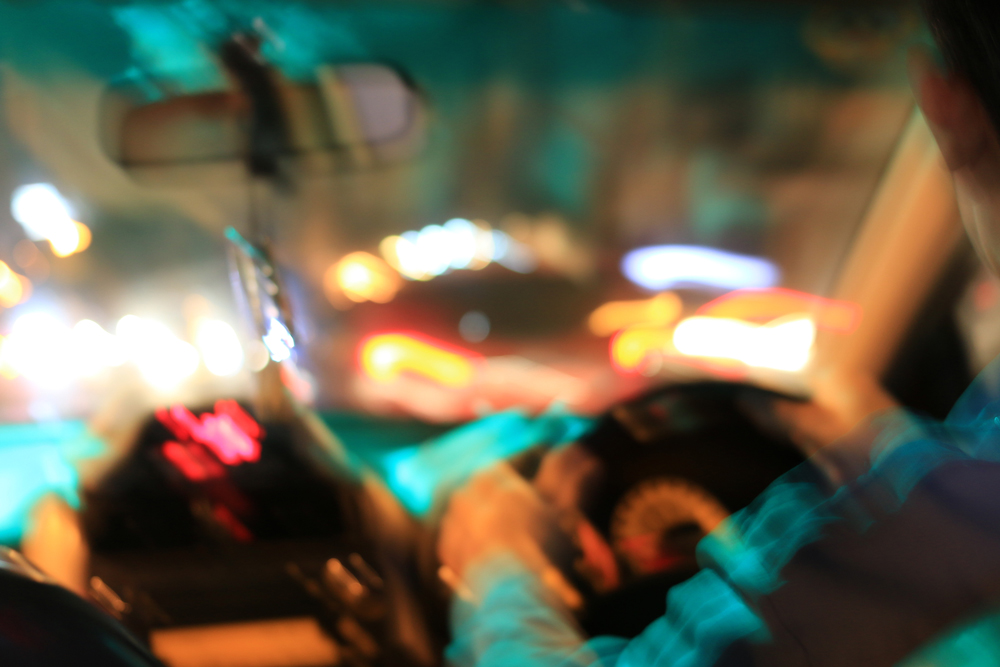 Driver experiencing sudden vision loss, blurred headlights, and glare while driving at night.
