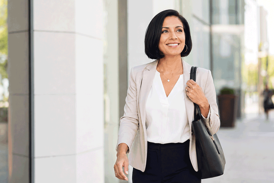 Professional 40-year-old Hispanic woman heading to a meeting, illustrating an active lifestyle for patients exploring EVO ICL after 40 at Barnet Dulaney Perkins Eye Center.