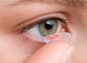 Close-up of a woman placing a soft specialty contact lens on her eye at Barnet Dulaney Perkins Eye Center.